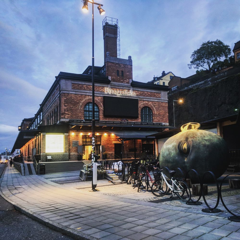 Caption: A photo of the brick, Art Nouveau exterior of Fotografiska, Stockholm’s contemporary art center, and the metal, spherical sculpture in front of it. (Local Guide Kira Rich)