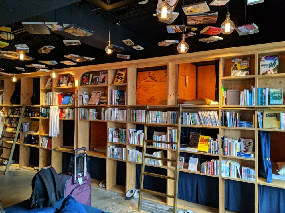 Caption: A photo of a massive bookshelf with sleeping bunks tucked inside of it at Book and Bed in Tokyo, Japan. (Local Guide kewei chen)