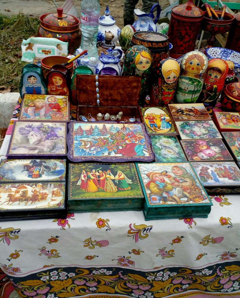 Caption: A photo of a table filled with Russian handcrafted objects including intricately painted boxes, Russian dolls, jars, and more. (Local Guide @INGA1)