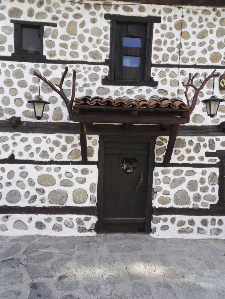 A photo of a traditional Bulgarian door on a white wall decorated with stones. (Local Guide @TsekoV)