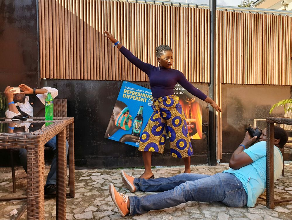 Caption: A photo of a Local Guide posing for a photo with her arms stretched as another Local Guide lays on the ground to take her photo during a meet-up in Lagos. (Local Guide @EmekaHouse)