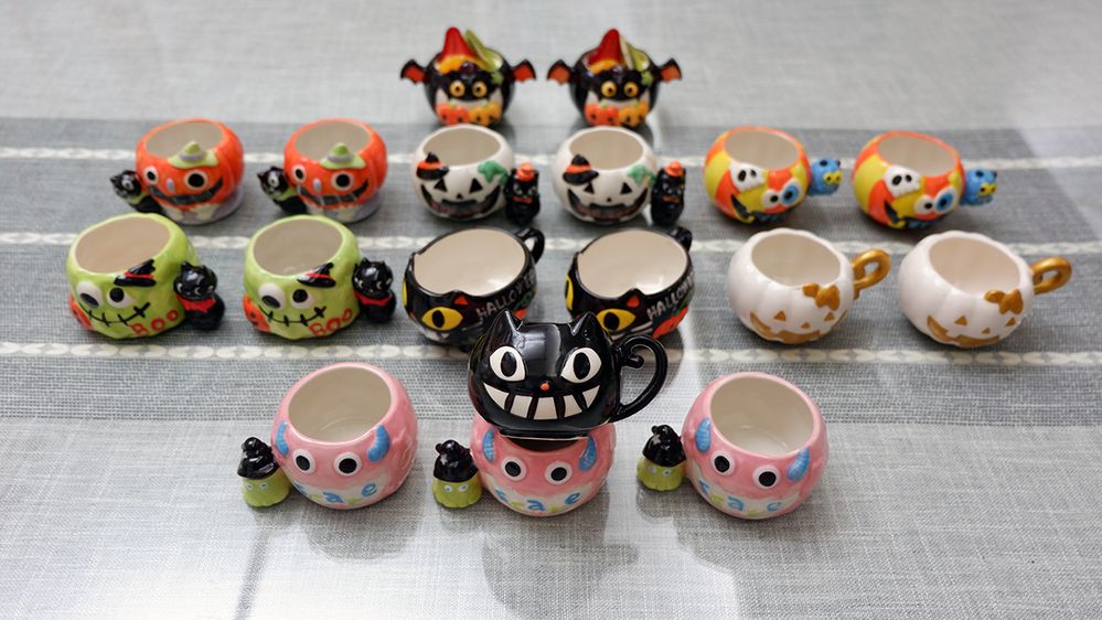Caption: A photo of rows of Halloween-themed cups designed to look like carved pumpkins, black cats, bats, and more on a table. (Local Guide @Koyowu)