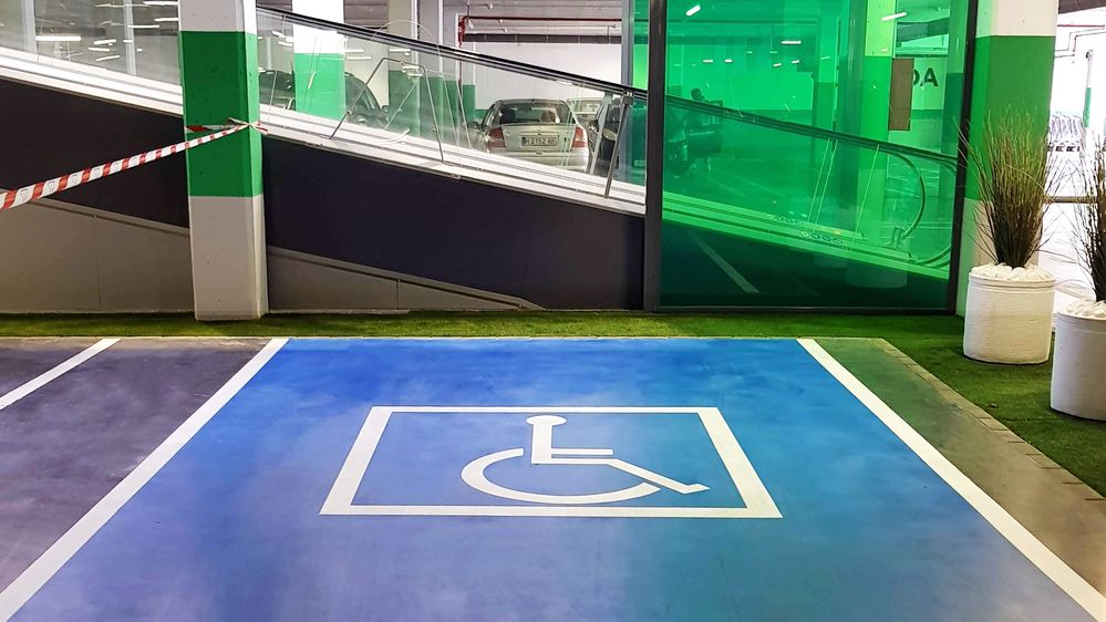 Caption: A photo of an accessible parking spot near an escalator in a parking garage in Isla Cristina, Spain. (Local Guide Alejandra B)