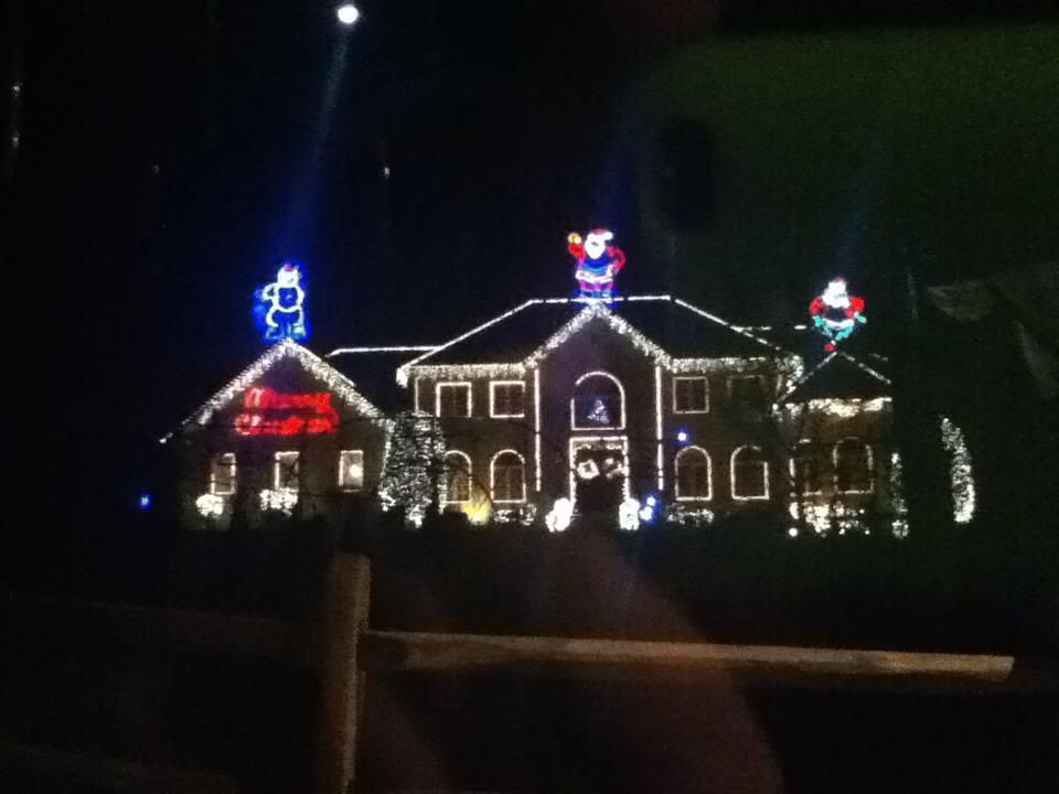 Legenda: Casa muito bem decorada com efeites de Natal, mostrando o Papai Noel e o Grinch.