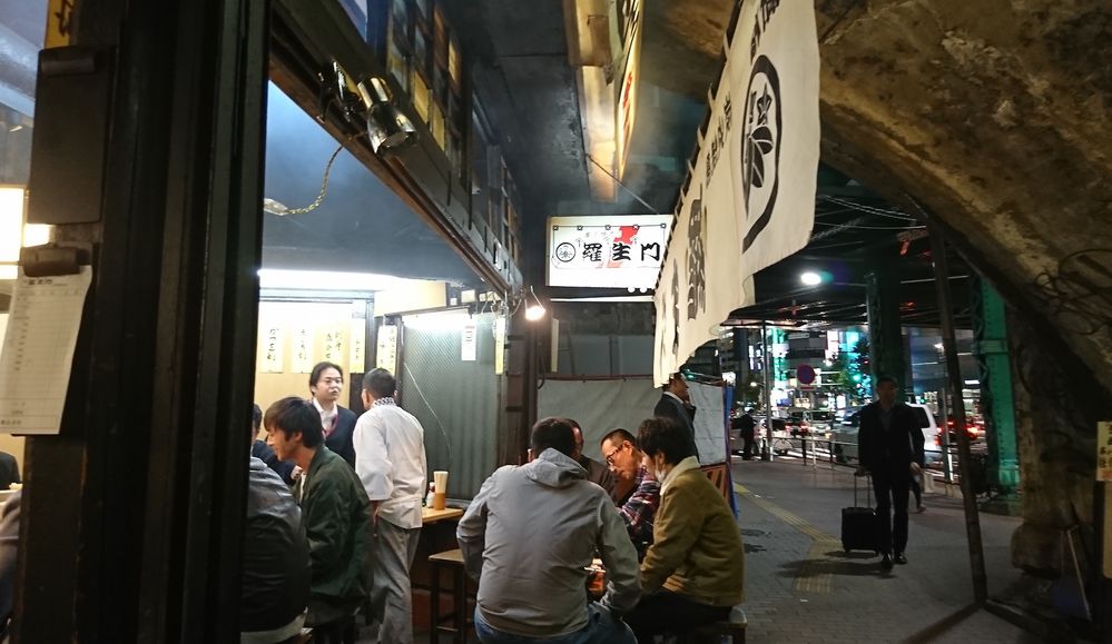 Caption: A photo of people drinking at an “Izakaya” under the train tracks at Shinbashi. (Local Guide 庄治悪原)
