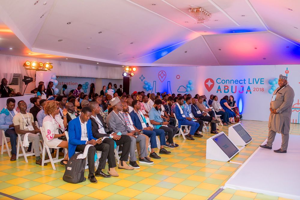 Caption: A photo of Local Guides sitting in the audience at Connect Live Abuja 2018 as Google Product Marketing Manager, Emmanuel “Biggy” Abiodun speaks on stage.