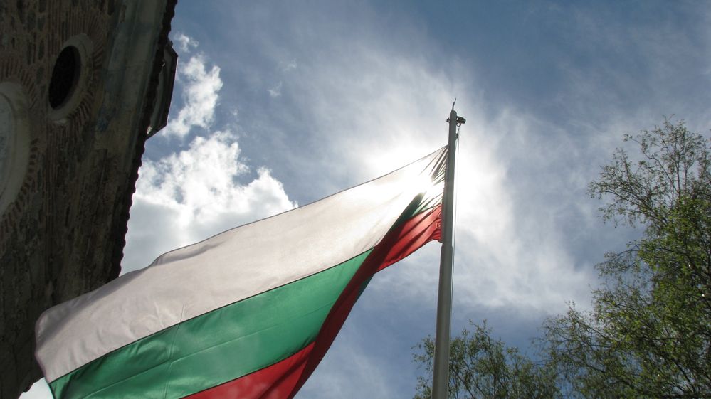 Caption: A picture of the bulgarian flag next to the church in Kalofer