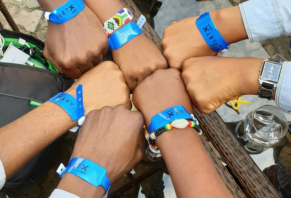 Caption: Nigerian Local Guides bump their fists together after a meetup in Lagos
