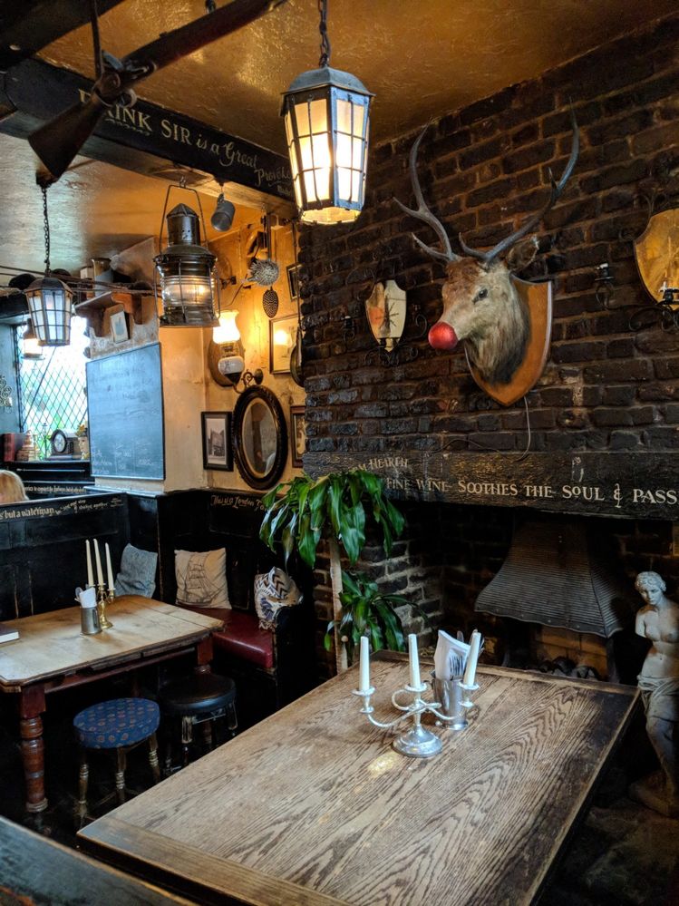 Caption: A photo of the interior of The Mayflower Pub, showing its charmingly old-world decor, wooden tables, and a taxidermied stag over the brick fireplace. (Local Guide K Thomas)