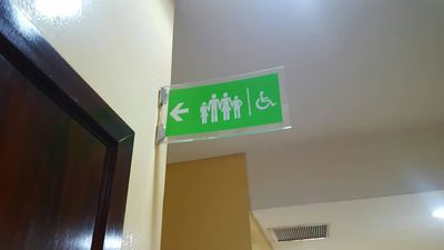 Caption: A direction sign showing the way to an accessible restroom at the Palms Mall Lagos