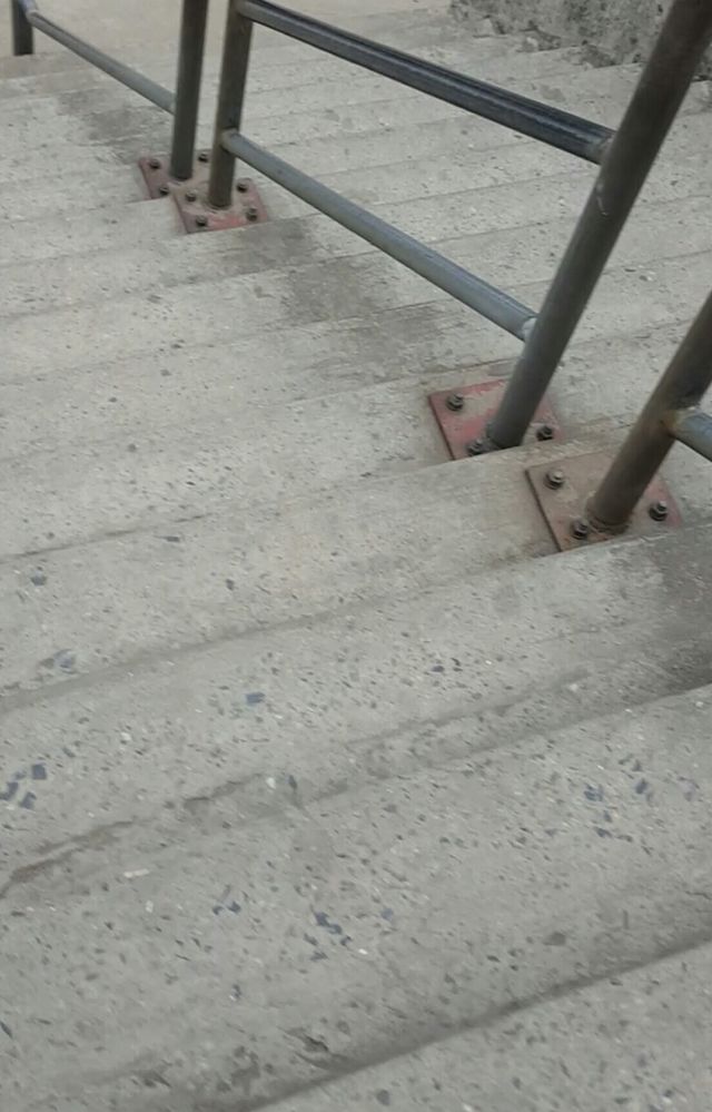 Caption: Pedestrian bridge with steep steps and metallic rail at Sandfill Bus Stop in Lagos