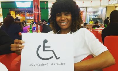 Caption: Local Guide Lydia holding an accessibility sign  attended a meeting for the first time.