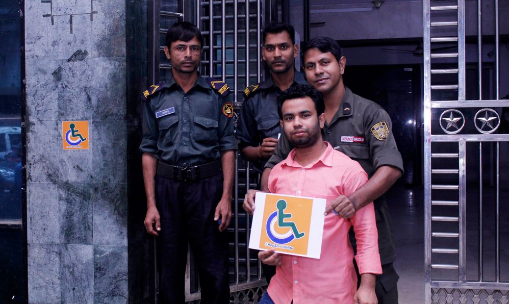 Security guards and building staffs were interested to  take a shot After marking a Building with Accessibility sticker .