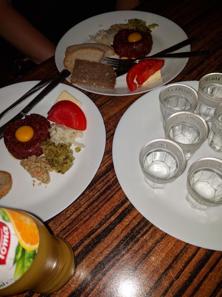 Caption: A photo of two plates with beef tartar and several shot glasses in the third plate. (Local Guide @MoniDi)