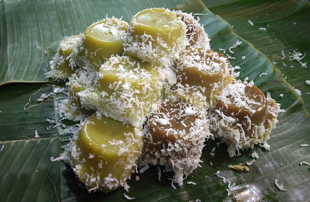 Caption: Tumpukan kue putu dengan taburan kelapa parut diatas daun pisang. (Getty Images)