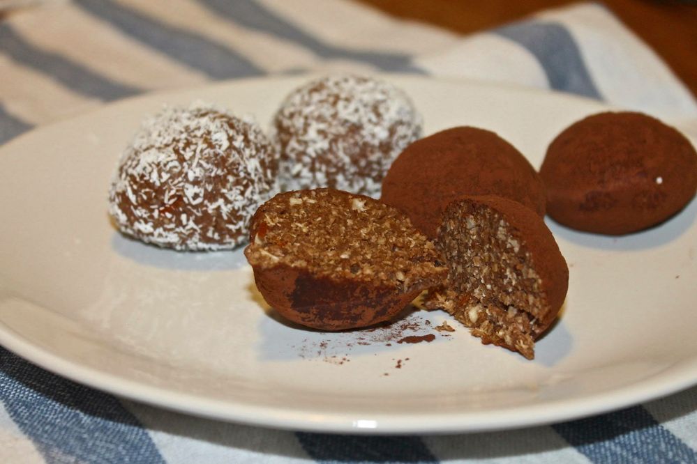 Caption: Raw oat bites with coconut flakes and cocoa powder.