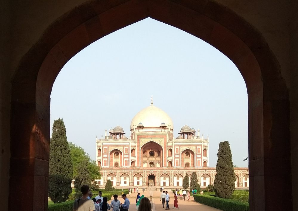 Caption: A photo of the exterior of Humayun’s Tomb surrounded by people taken from an entry way across from it in New Delhi, India. (Local Guide Amod Soni)