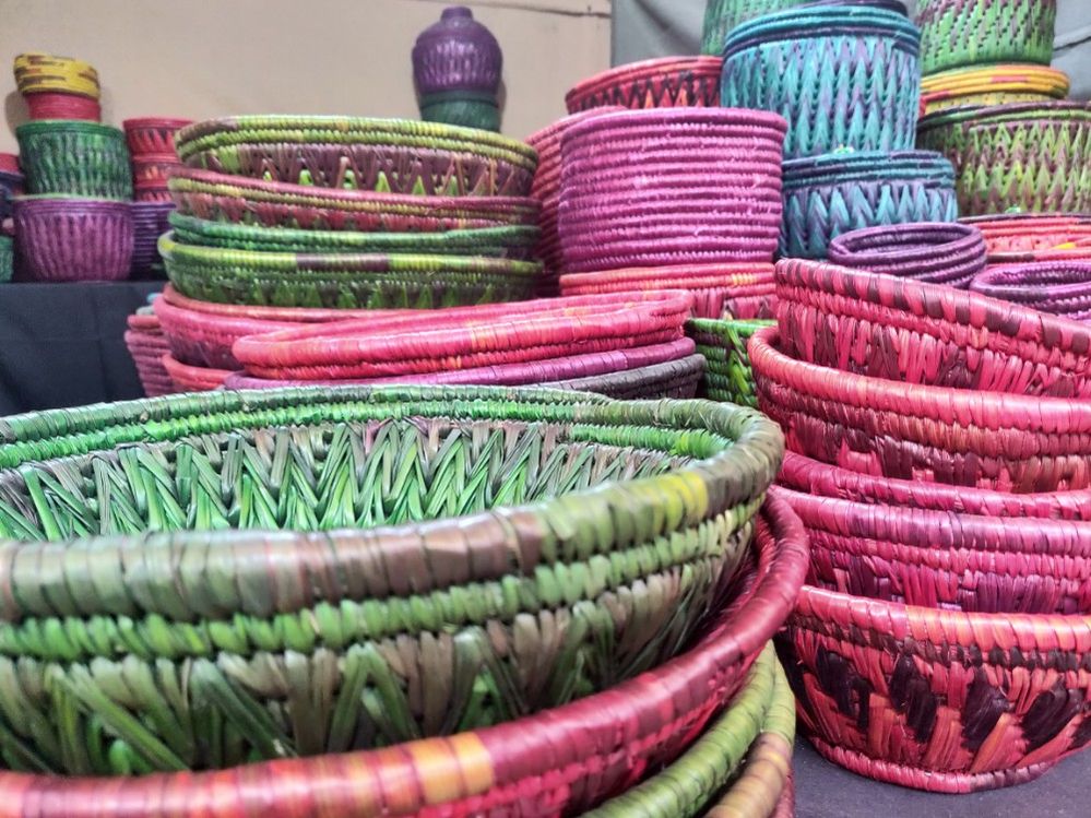 Caption: A closeup photo of colorful pink, green, blue, purple, and yellow baskets stacked on top of each other at Nature Bazaar Venue in Delhi, India. (Local Guide Harshita Verma)