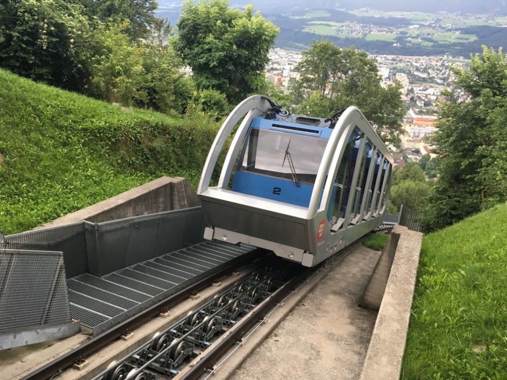 Caption: A photo of a cable car on a hill taken at Nordkette Cable Car in Innsbruck, Austria. (Local Guide Kanica Manchanda)