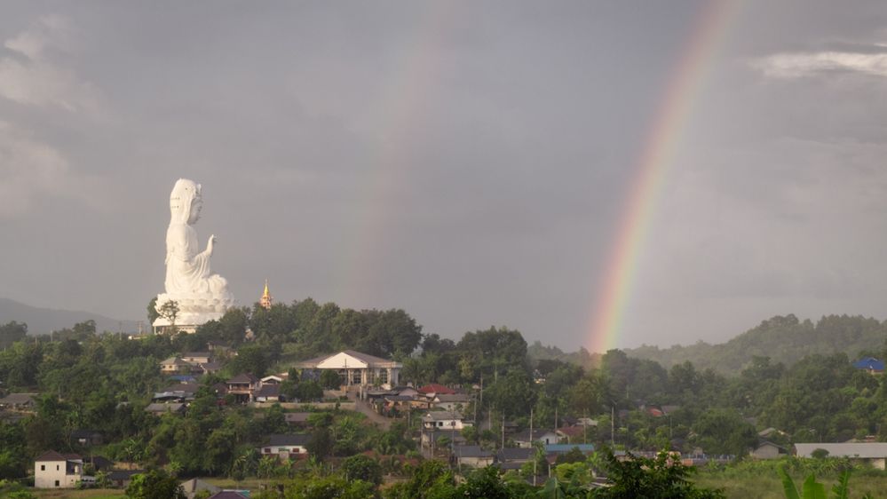 Double rainbow  breaks through stormy grey skies. Adjacent to the Guan Yin statue at Wat Hyua Pla Kang, Chiang Rai