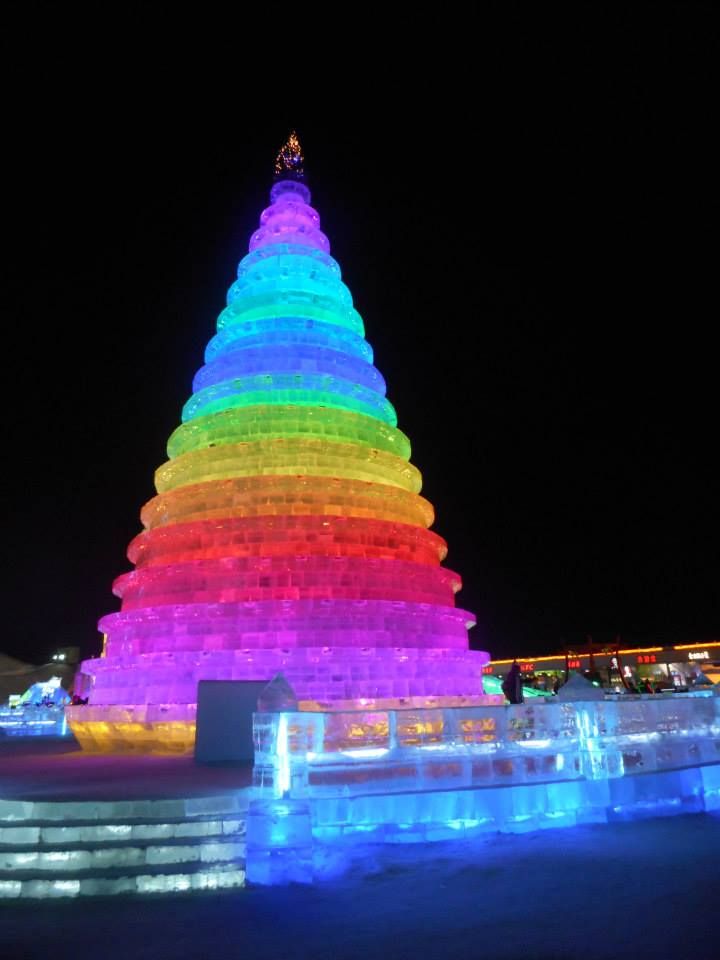 描述：在哈尔滨国际冰雪节拍的点亮着彩虹颜色的圣诞树冰雕的夜景照片。(本地向导 @TsekoV)