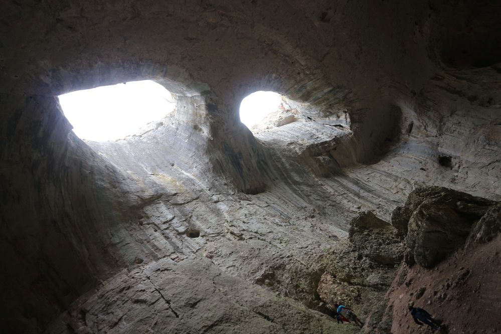 Caption: A photo from below of the roof of Prohodna cave, with two almond-shaped holes resembling eyes. (Local Guide @sonnyNg)