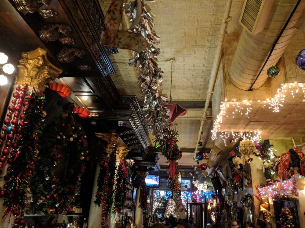 Caption: A photo of Christmas garlands, wreaths, baubles, lights, and more hanging inside of Lillie's Victorian Establishment, a Victorian-style pub in New York City. (Local Guide Alaa Ahmed)