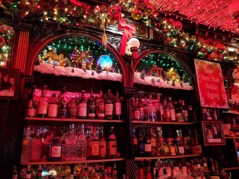 Caption: A photo of the inside of Pete’s Tavern in New York City during Christmastime, showing the red string lights that cover the ceiling and Christmas decorations on the bar. (Local Guide Bartosz Andrzej Roman)