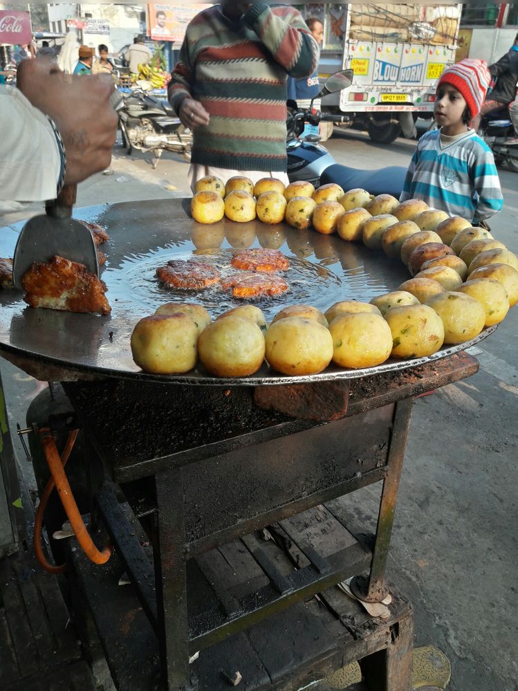 Shopkeeper making Aloo tikki and the customers waiting for his turn at a Tikki shop in Purquazi