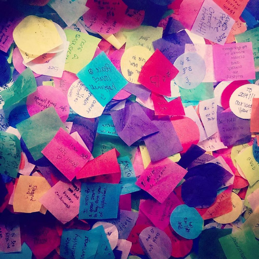 Caption: Confetti cut into squares and circles is shown with handwritten wishes for the New Year from inside of the pop-up wishing well in Times Square.