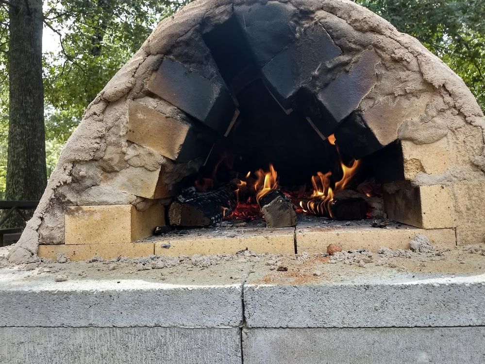 A fire burns happily in the earthen oven outside of Geoffrey's workplace. (G. Havens 2018)