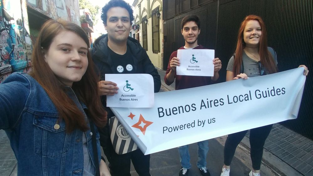 Caption: From left to right, me, Daniel, Santiago and Valeria. It is a selfie taken by me, with Daniel and Santiago holding signs that say "Accessible Buenos Aires", and Daniel and Valeria also holding the "Buenos Aires Local Guides" sign.