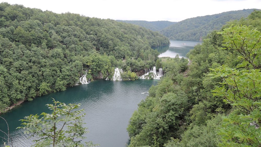 Fotografija snimljena s visine, vidna su nekoliko slapova koja padaju u duboko plavo-zeleno jezero u Plitvicama, Hrvatskoj. (Lokalni vodič @KatyaL)
