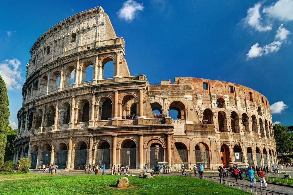 Caption: A photo of the Colosseum in Rome, showing the outside of the large three-tiered stone amphitheater that was once used for gladiatorial games. (Local Guide Piotr Kasperski)