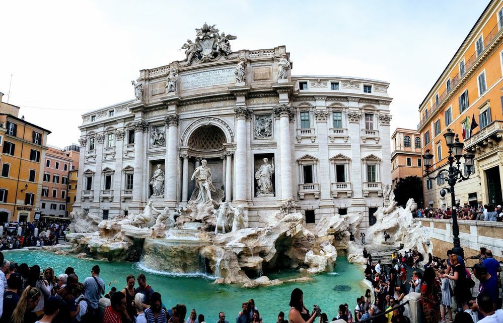 Caption: A photo of the Trevi Fountain, a famous Baroque fountain in Rome, showing the intricate stone carvings and statues on the fountain’s facade and the crowds of tourists that surround it. (Local Guide jeff browne)