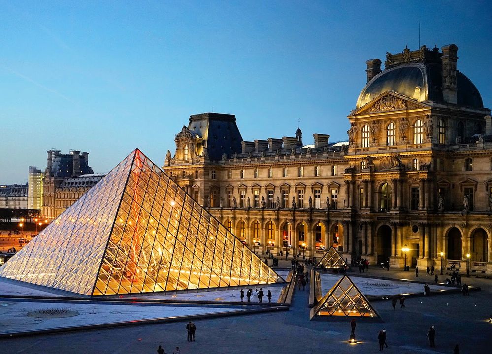 Caption: A photo of the Louvre Pyramid and the exterior of the Louvre Museum in Paris, France taken at sunset from a window outside Apollo’s Gallery. (Local Guide Jui Hong Teoh)