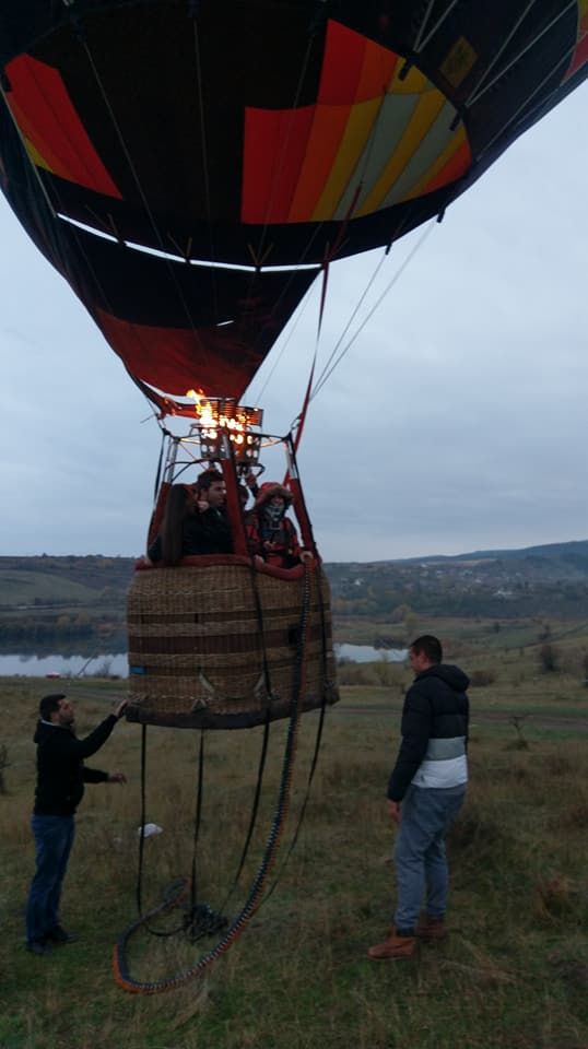 Caption: A photo of Google Moderator @DeniGu in orange jacket on board a hot air balloon, hovering close to the ground near Sofia, Bulgaria. (Local Guide Ivaylo Mihov)