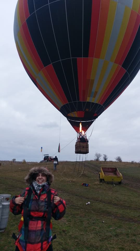 Caption: A photo of Google Moderator @DeniGu, smiling happily after completing a bungee jump from a hot air balloon. The hot air balloon can be seen in the background. (Local Guide Ivaylo Mihov)