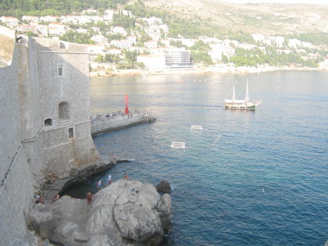 Caption: A photo of Dubrovnik Bay, Croatia. There is a boar visible in the sea and the photo is taken from the Dubrovnik walls from above. (Local Guide @KatyaL)