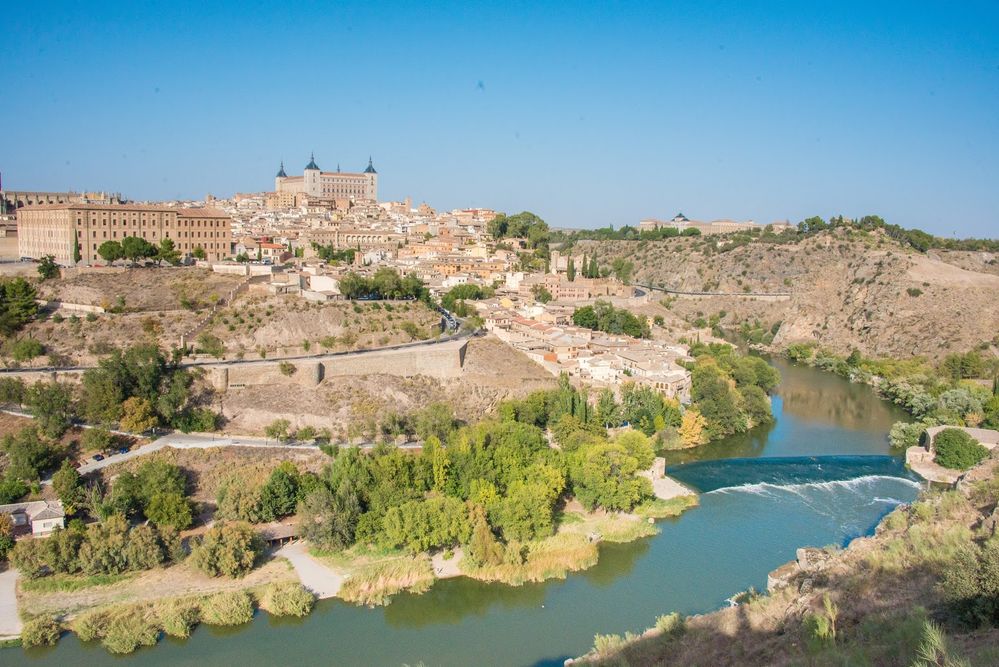 Caption: A photo of the view from Mirador del Valle, a scenic overlook that provides amazing views of the city of Toledo and the Tagus River. The photo shows the low stone buildings and houses that make up the city’s skyline. (Local Guide Joel Miyashiro)