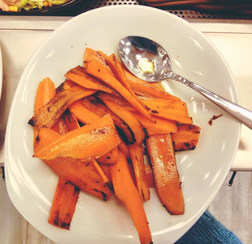 Caption: A plate with slightly stir fried carrots in butter, seasoned with salt and pepper. On the side there is a spoon to serve the carrots. (Local Guide VasT)