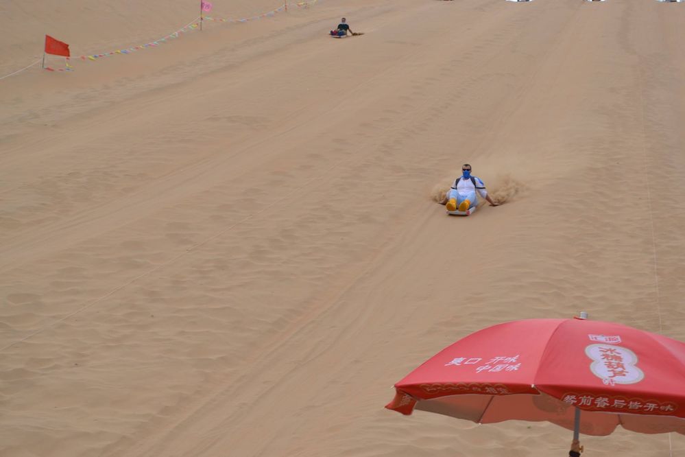 Caption: A photo of desert dunes and me sand sledding on the dune, Gobi desert, Inner Mongolia. (Local Guide @TsekoV)