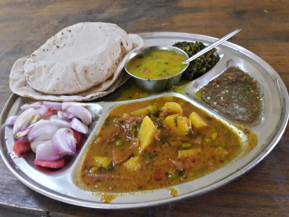 Caption: A complete veg thali which includes chapati (roti in India), mix vegetables of carrot and potatoes with some pears, pulses in boul, some salads and chutney. (Photo by Local Guide Ishant Gautam).