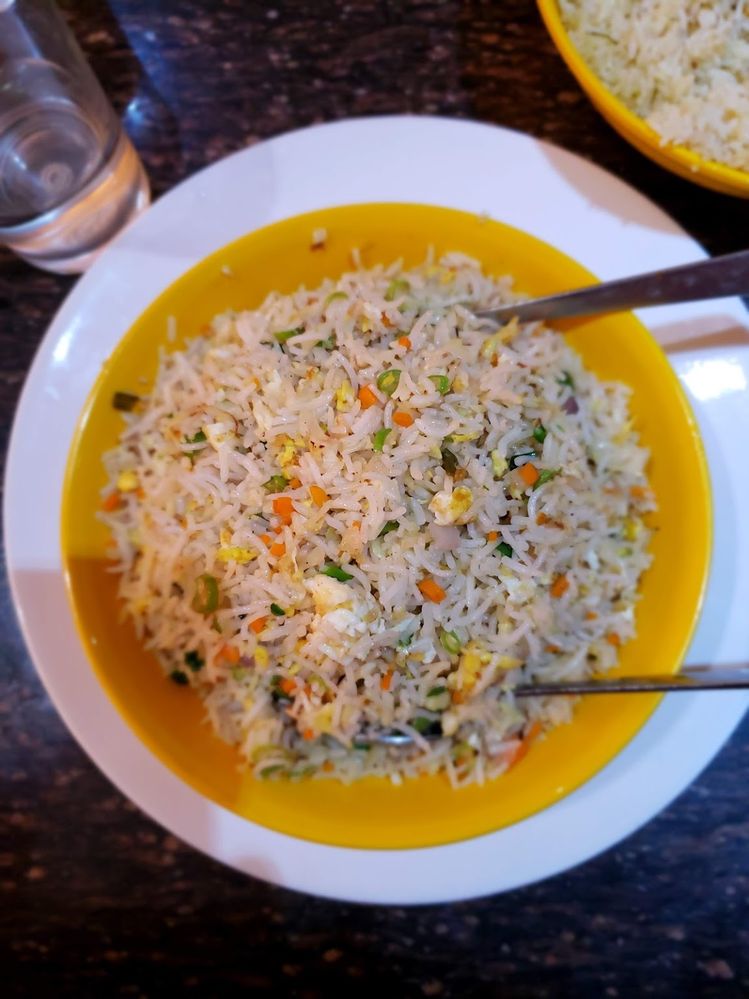 Caption: A photo of a yellow bowl of rice with egg and vegetables sitting on top of a white plate at Hotel Rahmath in Kozhikode, India. (Local Guide Ajay Patel)