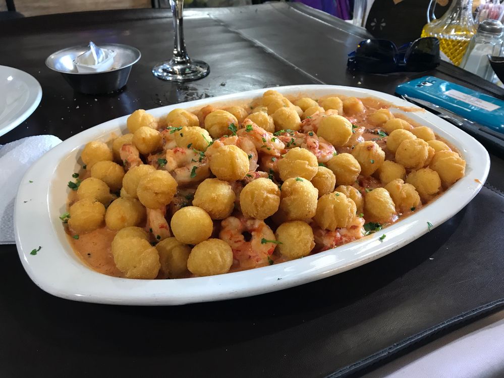 Caption: A photo of a dish with fried potato balls and shrimp at El Ferroviario in Buenos Aires. (Local Guide Xhavi Fr)