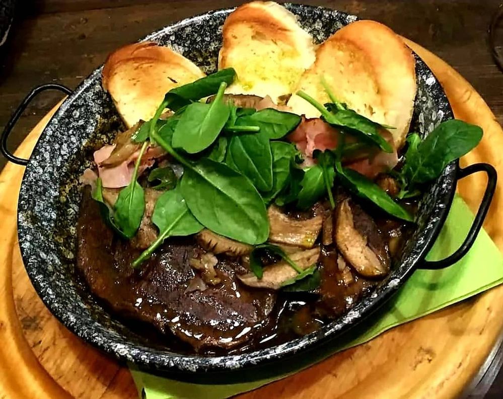 Caption: Photo of a beef stew with bead and some basil on the top (Local Guide Petra_M)