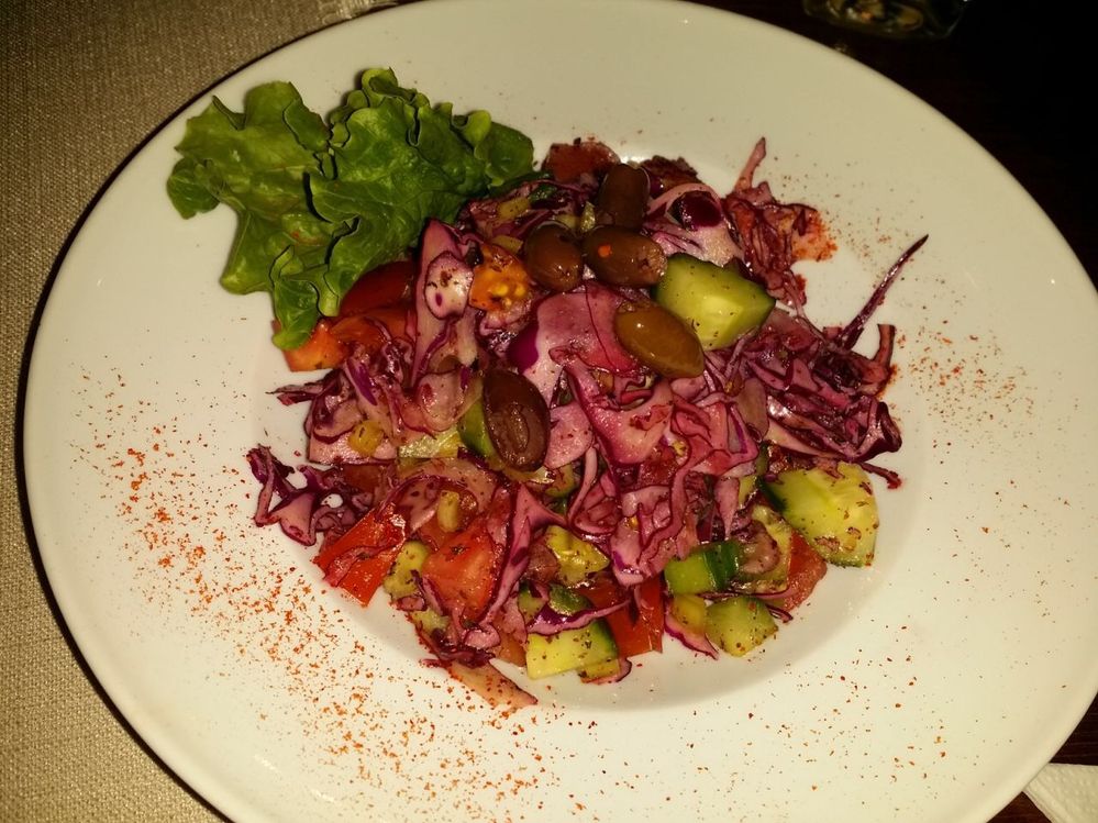 Caption: A photo of vegetable salad with tomatoes, cucumbers, cabbage, olives, walnuts (Local Guide @KatyaL)