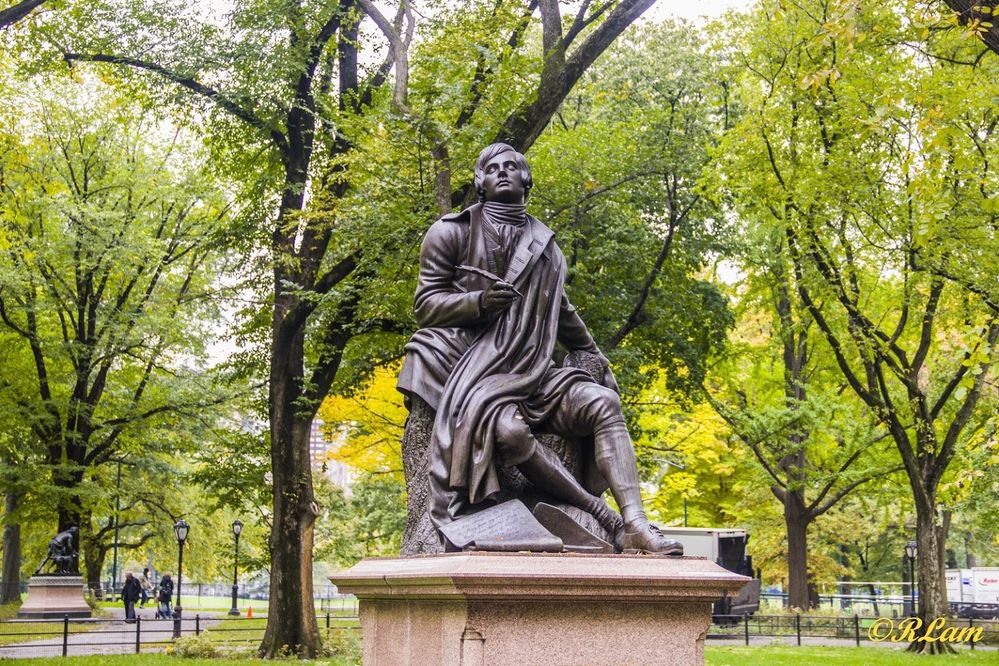 Caption: A photo of a statue of the Scottish poet Robert Burns surrounded by leafy trees at the Literary Walk in New York City’s Central Park. (Local Guide Robert Lam)