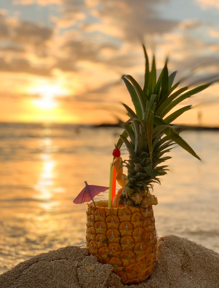 Pineapple in front of sunset on Waikiki Beach, Hawaii.