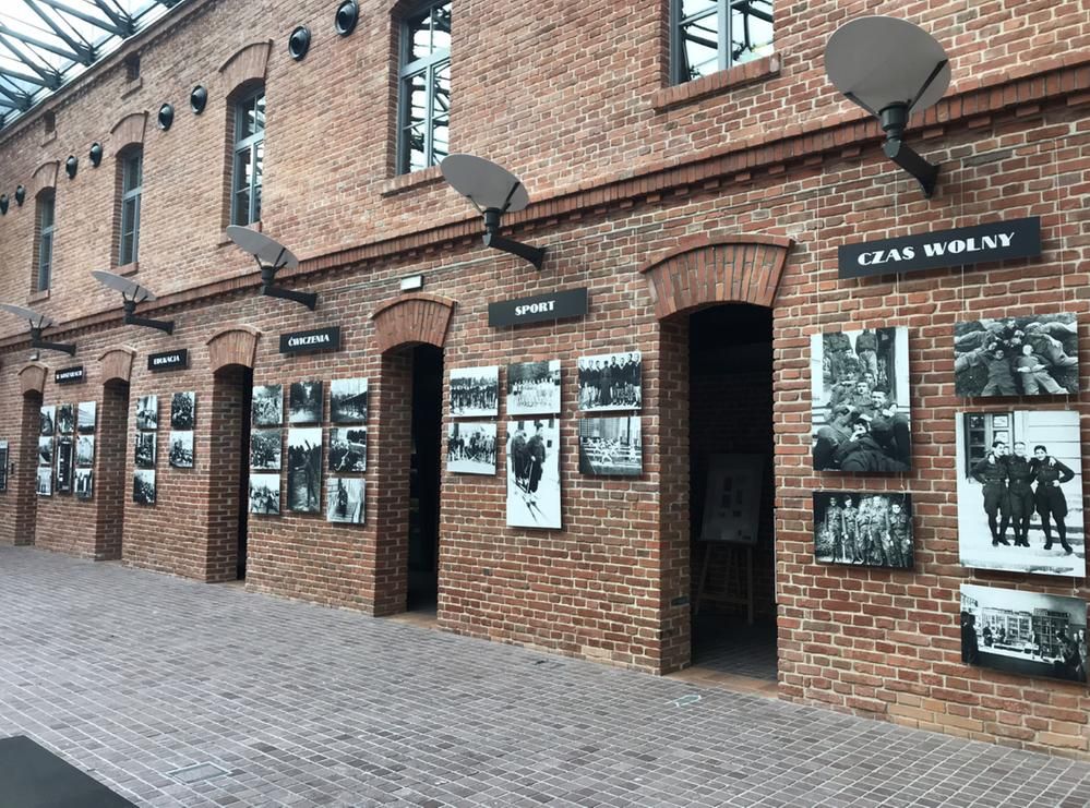 Caption: A photo of a brick wall with many black and white photos, entryways, and windows at the Museum of Polish Army AK in Kraków, Poland. (Local Guide @TorM)